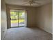 Bedroom with ceiling fan, neutral walls, and sliding glass door to balcony at 4596 Pheasant Run Dr # C, Orlando, FL 32808