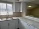 Bright kitchen features stainless steel sink, modern faucet, white cabinets and countertops at 4596 Pheasant Run Dr # C, Orlando, FL 32808
