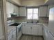 Bright kitchen features stainless steel sink, modern faucet, white cabinets and countertops at 4596 Pheasant Run Dr # C, Orlando, FL 32808