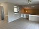 Open living room area with tile flooring, neutral-colored walls and a pass-through to the kitchen at 4596 Pheasant Run Dr # C, Orlando, FL 32808
