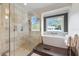 Luxurious bathroom featuring a walk-in shower and a soaking tub by a bright window at 521 S Phelps Ave, Winter Park, FL 32789
