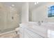 Bright bathroom with a glass shower, modern vanity, and a large framed mirror at 521 S Phelps Ave, Winter Park, FL 32789