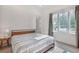 Cozy bedroom with a minimalist bed frame, side table, and a view of the outdoors at 521 S Phelps Ave, Winter Park, FL 32789
