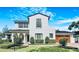 Stunning two-story white home featuring arched entry, front balcony, well-manicured landscaping and a wood-look garage door at 521 S Phelps Ave, Winter Park, FL 32789