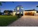 Elegant home with a paver driveway, lush lawn, and a side-entry garage at twilight at 521 S Phelps Ave, Winter Park, FL 32789