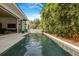 A view of the rectangular pool lined with bamboo, with a home featuring sliding glass doors for seamless indoor-outdoor living at 521 S Phelps Ave, Winter Park, FL 32789