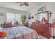 A bright bedroom with a ceiling fan, a large mirror and dresser, and artwork on the wall at 5234 Bear Corn Run, Port Orange, FL 32128