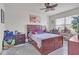 A spacious bedroom with a wooden bed frame, a ceiling fan, and a bright window at 5234 Bear Corn Run, Port Orange, FL 32128