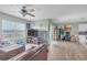 Bright living room featuring wood flooring, a ceiling fan, and large windows with views of the lake at 5234 Bear Corn Run, Port Orange, FL 32128