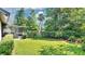Well-manicured backyard with lush green lawn, beautiful landscaping, and an inviting screened-in patio at 623 Tuskawilla Point Ln, Winter Springs, FL 32708