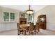 Dining room featuring a chandelier, classic wooden furniture, and two shuttered windows at 623 Tuskawilla Point Ln, Winter Springs, FL 32708