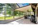 Extended screened patio with a brick floor, ceiling fans, and a view of the spacious, grassy yard at 623 Tuskawilla Point Ln, Winter Springs, FL 32708