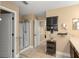 Well-lit bathroom with a glass-enclosed shower, vanity, and convenient storage shelves at 7003 Cupseed Ln, Harmony, FL 34773