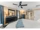 Comfortable bedroom boasts a ceiling fan, dresser with mirror, and a cozy bed with a blue blanket at 7003 Cupseed Ln, Harmony, FL 34773