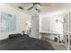 Bright bedroom featuring a large bed, ceiling fan, work desk and adjacent bathroom at 7003 Cupseed Ln, Harmony, FL 34773