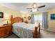 Inviting bedroom with a wooden bed frame, patterned bedding, and a ceiling fan for added comfort at 7003 Cupseed Ln, Harmony, FL 34773