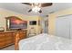 Bedroom featuring a wooden bed frame, TV, ceiling fan, and neutral color scheme at 7003 Cupseed Ln, Harmony, FL 34773