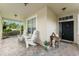 Welcoming front porch with brick flooring, seating, and a view of the garden, perfect for relaxing outdoors at 7003 Cupseed Ln, Harmony, FL 34773