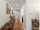 Inviting hallway with wood floors and decorative accents leading to various rooms in the home at 7003 Cupseed Ln, Harmony, FL 34773