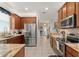 Kitchen featuring stainless steel refrigerator, granite countertops, and wood cabinets at 7003 Cupseed Ln, Harmony, FL 34773