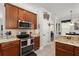 Spacious kitchen with stainless steel double oven, microwave, and granite countertops at 7003 Cupseed Ln, Harmony, FL 34773