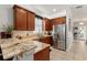 Kitchen with stainless steel refrigerator and sink, granite countertops, and wood cabinets at 7003 Cupseed Ln, Harmony, FL 34773