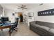 Cozy living room with modern sofa, adjacent kitchen, and desk workspace, a great flexible space at 7003 Cupseed Ln, Harmony, FL 34773
