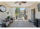 Relaxing screened patio with brick flooring, comfortable chairs, and a view of the garden area at 7003 Cupseed Ln, Harmony, FL 34773