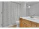 Cozy bathroom with wood vanity, framed mirror, neutral tile flooring, and shower with floral curtain at 758 E Michigan St # 203, Orlando, FL 32806