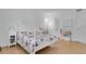 Bright bedroom featuring a white iron bed frame with floral comforter and a white nightstand at 758 E Michigan St # 203, Orlando, FL 32806