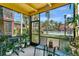 Screened-in porch overlooking a pool, lush green space, palm trees, and community buildings at 758 E Michigan St # 203, Orlando, FL 32806
