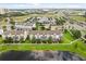 Aerial view showcasing townhomes, lush landscaping, and a serene pond within the community at 7724 Sweet Star Ave, Orlando, FL 32836