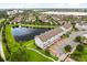 Aerial view featuring townhomes nestled by a peaceful lake and meticulously maintained grounds at 7724 Sweet Star Ave, Orlando, FL 32836