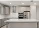Modern kitchen with stainless steel appliances, grey cabinetry, and white subway tile backsplash at 7724 Sweet Star Ave, Orlando, FL 32836