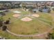 An aerial view of baseball fields in a community surrounded by a lake and tennis courts at 824 Spring Island Way, Orlando, FL 32828