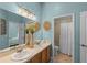 Bright bathroom features double sinks, wooden cabinets, and a shower with a white curtain at 824 Spring Island Way, Orlando, FL 32828