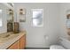 Simple bathroom featuring a light wood vanity, a window, and a clean, functional toilet at 824 Spring Island Way, Orlando, FL 32828