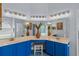Bright bathroom with double vanity, blue cabinets, decorative mirrors and modern lighting at 824 Spring Island Way, Orlando, FL 32828
