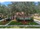 An inviting home with a well-manicured lawn, lush landscaping, and mature trees for shade at 824 Spring Island Way, Orlando, FL 32828
