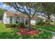 Charming single Gathering home featuring lush landscaping, large shade tree and a manicured lawn at 824 Spring Island Way, Orlando, FL 32828