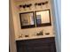 Bathroom vanity with double sinks, dark wood cabinets, modern lighting, and decorative mirrors at 8539 Clematis Ln, Orlando, FL 32819