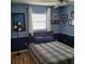 Comfortable bedroom with blue walls, bright window, ceiling fan, and wood floors at 8539 Clematis Ln, Orlando, FL 32819