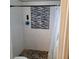 Shower with pebble floor, white tile, and mosaic accent tile panel at 8539 Clematis Ln, Orlando, FL 32819