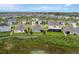 An aerial view captures a residential area with houses, a pond, and greenery creating a neighborhood at 868 Brooklet Dr, Davenport, FL 33837