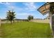 A grassy backyard with views of a fence, pond, and trees presents a serene and private outdoor space at 868 Brooklet Dr, Davenport, FL 33837