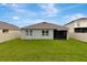 The backyard features a well-maintained lawn, privacy fence, and a screened-in porch of the gray home at 868 Brooklet Dr, Davenport, FL 33837