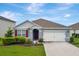 Charming single-story home with a well-manicured lawn, a two-car garage and red shutters at 868 Brooklet Dr, Davenport, FL 33837