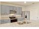 Close-up of a kitchen with granite countertops, stainless steel appliances and gray cabinets at 868 Brooklet Dr, Davenport, FL 33837