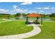 Scenic picnic area with shelter overlooking a pond with fountain and walking path at 868 Brooklet Dr, Davenport, FL 33837