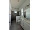Bright bathroom featuring a shower with gray tile, a white vanity, and a window at 931 Azalea Walk Cir, Deland, FL 32724